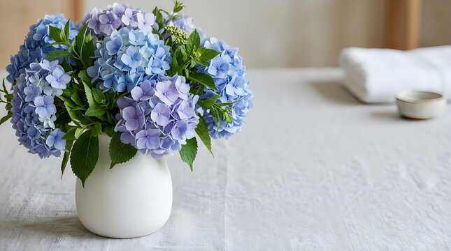 Minimalist blue hydrangea flowers in white vase on rustic wooden table