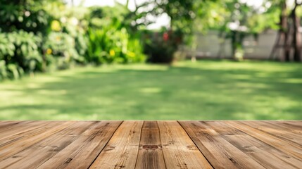 Naklejka premium Wooden tabletop in foreground with blurred garden and lawn background