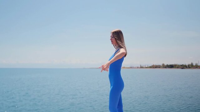 young woman practicing yoga poses on wooden pier by sea enjoying sunlight freedom and healthy lifestyle with scenic nature background travel wellness, woman performing dynamic yoga workout