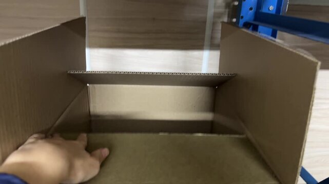 Woman folding cardboard box for packing goods. Hands close-up
