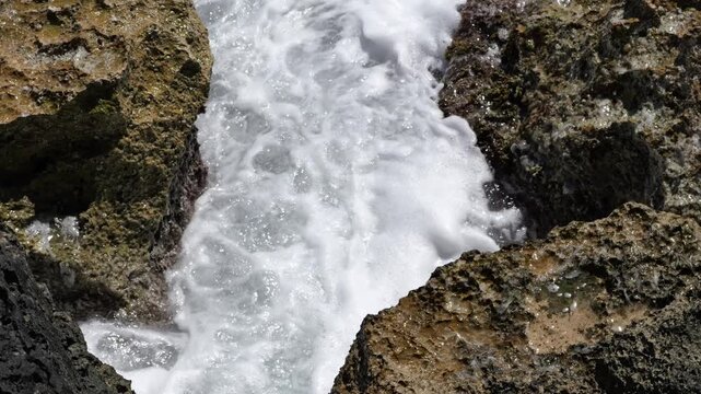 Surf crashes through a crevice in the rocks on the coast of Mallorca. Ideal for nature or background videos.4K UHD (3840x2160), 25fps, 46 seconds, 676 MB.