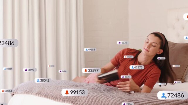 Woman settling on bed and causing animated alerts while toggling phone and reading book for tech