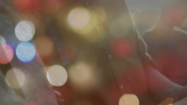 Vertical video: Pulling camera down, two males peering at handheld device on bench, sharing