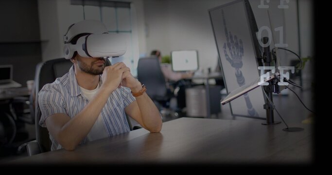 Leaning dev wearing striped shirt white VR headset viewing 3D robot hand render, wooden office desk