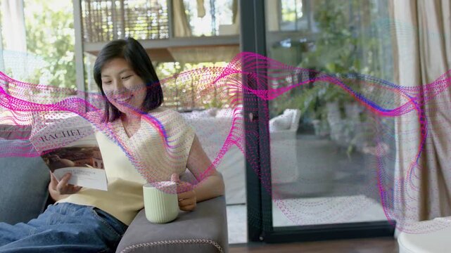 Woman reading RACHEL on sofa holding green mug, pink purple wave sweeping, sparking lifestyle smile