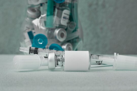 Close-up of used medical supplies and empty vials for recycling.
