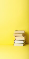 Fototapeta premium Short stack of books placed on yellow seamless background surface