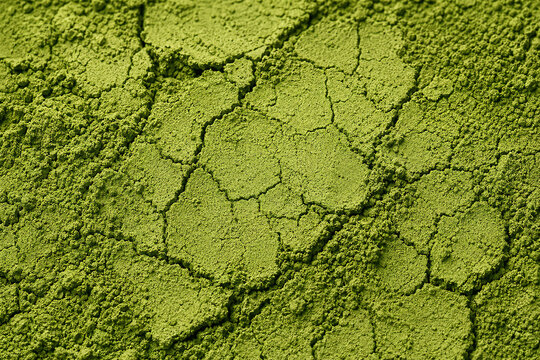 Green powder shows fine texture and cracks on surface under bright light in close-up view