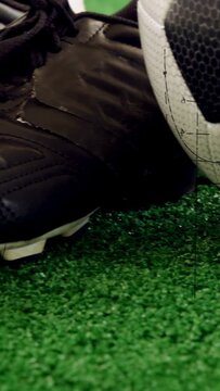 Vertical video: Kick-triggered ball rolling into black cleat, pressing, revealing calibration marks