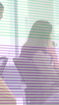 Vertical video: Worker raising phone to ear making work call while color bars glitching over chairs