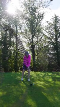 Vertical video: Senior golfer addressing ball then swinging driver, driving ball amid halftone dots