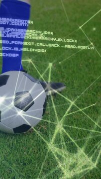 Vertical video: Web overlay rising, player leg tapping soccer ball on grass, code showing analytics