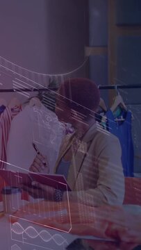 Vertical video: Stylist checking rack for design peer tapping tab starting holo noting red notebook