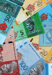 Malaysian ringgit money banknotes pile on table. Malaysia bills of MYR currency close up © Larysa