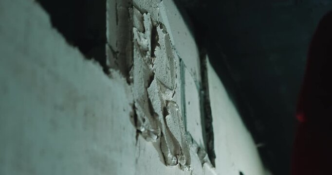 Applying plaster onto wall surface with trowel during finishing close up