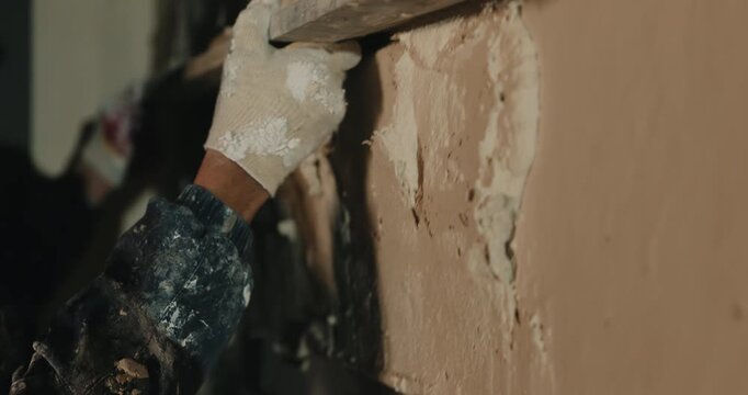 Leveling plaster on wall surface with trowel during finishing close up