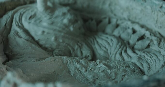 Mixing cement mortar in bucket with electric mixer close up