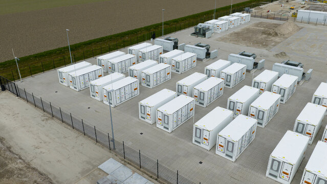 Dronten, Netherlands - 04 April 2026: Aerial view of the battery energy storage system at Olsterdwarspad with rows of white container units and industrial equipment.