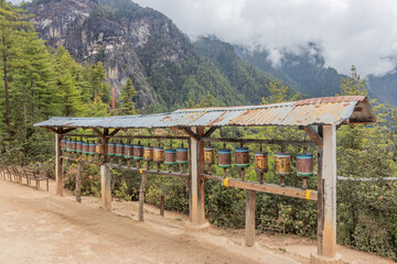 Fototapeta premium Prayer wheels in a forest near Paro Taktsang (Taktsang Palphug Monastery or the Tiger's Nest), Bhutan.