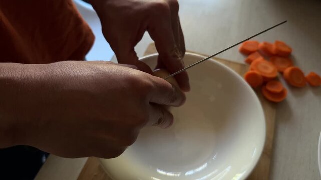 Close-up of a man cracking an egg into a white bowl on a kitchen counter