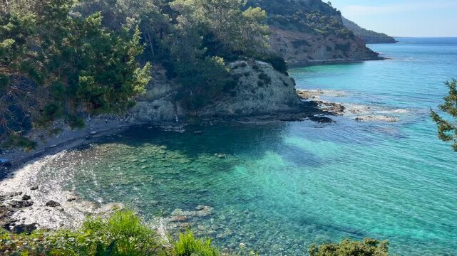 Green bay in Mediterranean Cyprus Akamas with turquoise water and rocky coast, ideal for tourism and resort marketing. Scenic landscape highlights relaxation and coastal destination