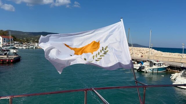 Cyprus flag waving in marina with boats and yachts in Latchi harbor, ideal for tourism and national branding. Coastal scene highlights identity, travel and Mediterranean lifestyle
