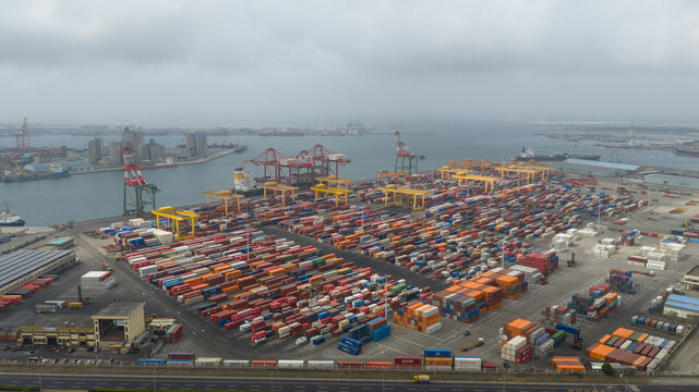 Haibin Village, Taiwan - 23 February 2026: Aerial view of Port of Taichung Berth 9 with rows of colorful shipping containers and industrial cranes under an overcast sky.