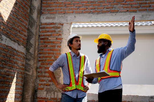 Civil engineer and construction worker manager discussing building site inspection , talking and plan about construction site. Cooperation teamwork. safety gear, project management concept.