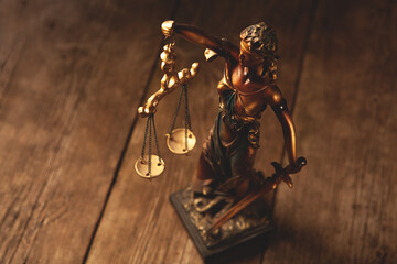 Statue of justice on wooden background. Law and justice concept. © Artvibe
