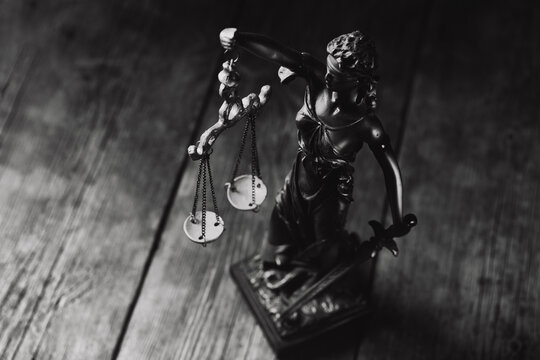Statue of justice on wooden background. Law and justice concept.