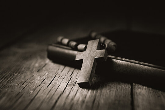 wooden cross and bible on a wooden table, shallow depth of field
