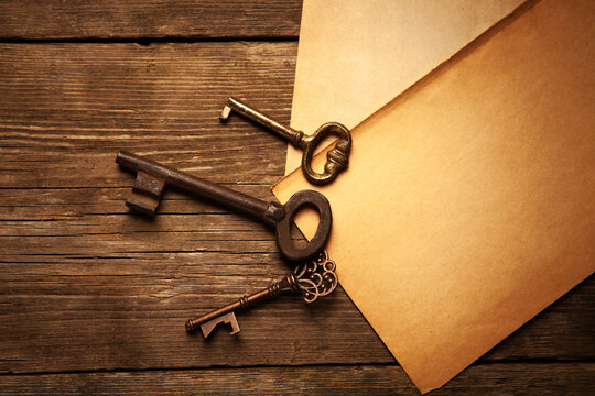 Old key and old book on wooden table. Shallow depth of field