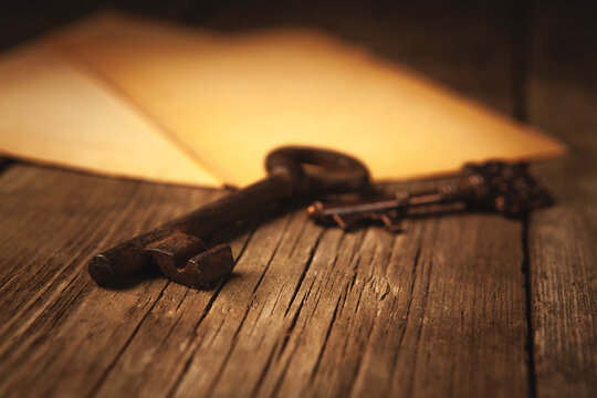 Old key and old book on wooden table. Shallow depth of field