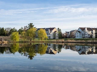 Fototapete Reflection Ashburn Village willow trees and townhomes reflected in a calm pond  © Karlsson Photo