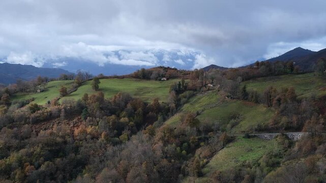 Breathtaking panoramic view of the rolling green hills and autumn forests in San Martin del Rey Aurelio, Asturias.