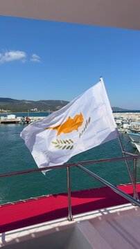 Cyprus flag waving from boat deck over blue sea, symbolizing national tourism identity, maritime travel, coastal adventure, and Mediterranean destination marketing.