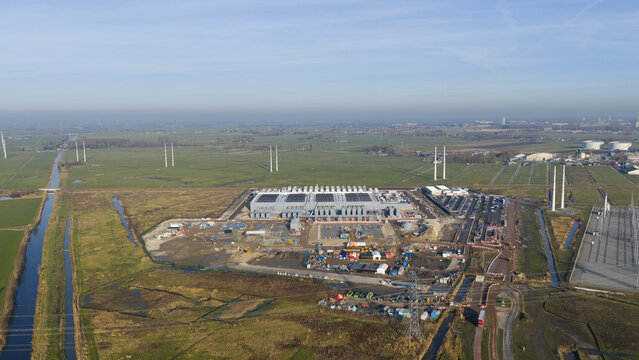 Groningen, Netherlands - 20 January 2026: Aerial view of Datacenter Westpoort surrounded by green fields, canals, and power lines under a clear sky.