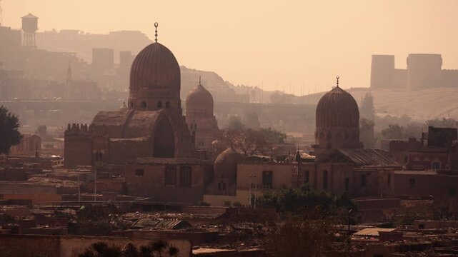 Zoom view of Cairo City of the Dead with mosque domes rising above buildings. Zoom footage capturing the historic Cairo City of the Dead. In the center of the frame, several mosque domes rise 
