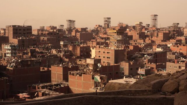 Elevated view of Cairo Garbage City with dense brick buildings and rooftop structures. Elevated view over Cairo&rsquo;s Garbage City showing dense rows of similar brick residential buildings.