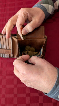  Close-up of senior holding open wallet with coins, cost of living concept
