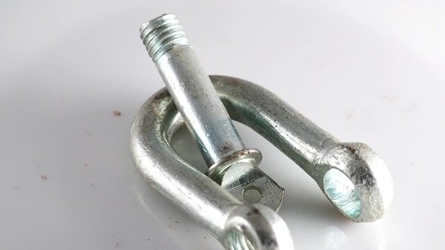 Heavy duty metal d shackle rotating on white background