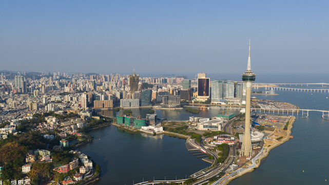 Macao - 18 February 2026: Aerial view of the Macau Tower and the city skyline including the Grand Lisboa hotel overlooking Nam Van Lake under a clear blue sky.