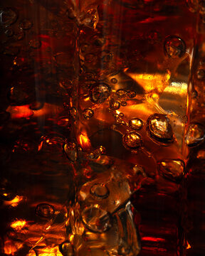 Vertical macro ice cubes in sparkling liquid, refreshing drink background