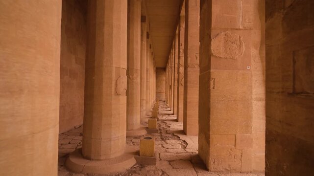 Architectural Details &ndash; Hatshepsut Temple. Smooth cinematic shot moving between columns of Hatshepsut Temple in Luxor. On one side, round fluted columns; on the other, square columns
