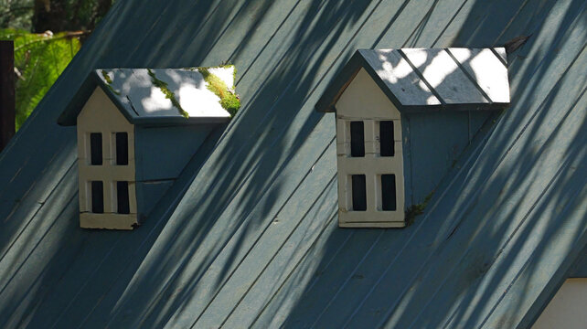 The photo shows the decorative dormer windows of the cottage