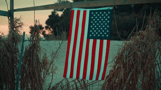 On a beach at night an American flag flutters softly during memorial day