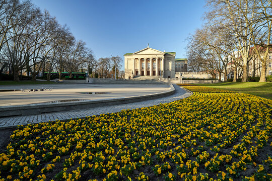 Flowerbed and front facade of the historic opera building in Poznan