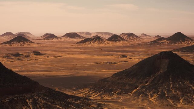 Handheld panoramic shot of Egypt&rsquo;s Black Desert with basalt-covered volcanoes. Smooth handheld panorama of Egypt&rsquo;s Black Desert, capturing numerous volcanoes covered in dark basalt. 