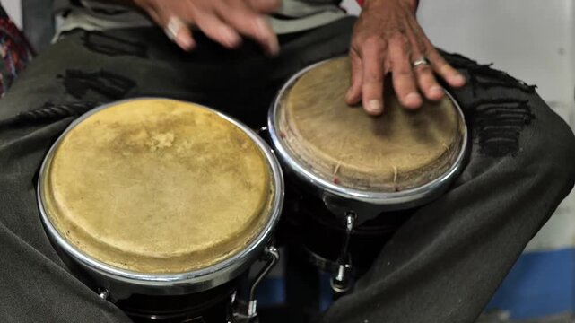 Manos de hombre tocando instrumento tambor doble de percusi&oacute;n