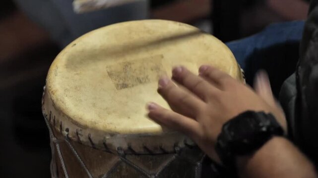 Manos de hombre tocando tambor de percusi&oacute;n